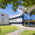 Contemporary hospital with large windows and clear signage, set in landscaped grounds. Accessible entrance under a bright canopy.