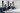 Two healthcare professionals in blue scrubs review documents at a white desk in a calm, well-equipped private hospital setting.