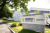 The Burnside Hospital Stepney sign is located on a well-kept lawn in front of a modern white facility with trees and a sidewalk nearby.