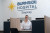 A friendly receptionist in glasses and a white shirt welcomes visitors at Burnside Hospital Stepney's modern, bright reception area.