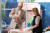 In a well-lit private hospital room, smiling parents care for their healthy, swaddled newborns, ensuring comfort and safety.