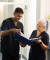 Two healthcare professionals in navy uniforms review documents together in a bright, modern medical facility, smiling confidently.
