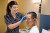 A healthcare professional gently applies electrodes to a relaxed patient's face and head in a private hospital for a diagnostic test.