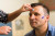 A healthcare professional gently applies electrodes to a man's forehead and cheek for a routine medical or sleep assessment.