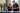 Two healthcare professionals in navy uniforms review patient files at a welcoming reception desk, with fresh flowers and natural light.